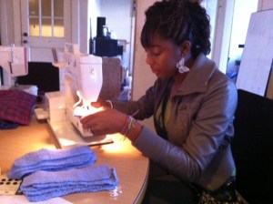 Tyra sewing reusable cloth menstrual pads at the FCF Raleigh office.